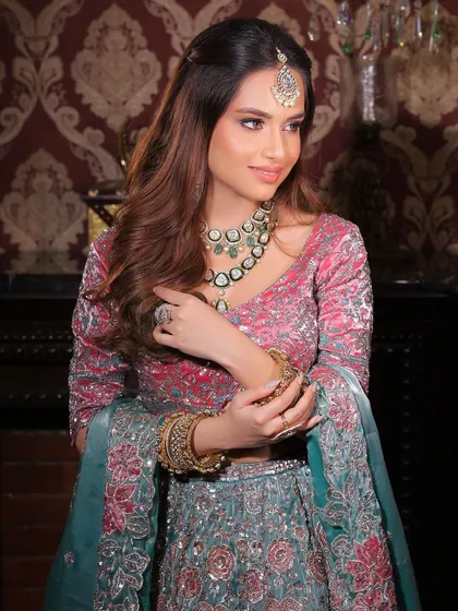A beautiful, soft smile from a wedding guest. The makeup is glamorous but not overpowering, with a focus on radiant skin and defined eyes.
