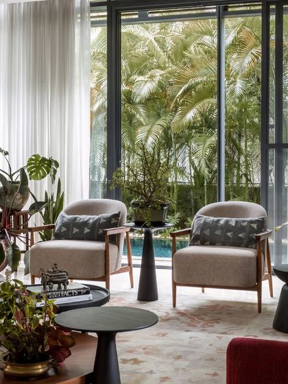 A closer look at the seating nook by the window, where natural light floods the space and highlights the textures of the upholstery and rug.