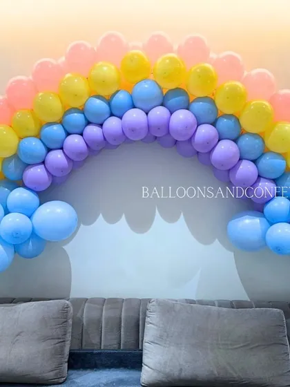 A close-up of the pastel rainbow balloon arch, showing the gentle gradient of colors.