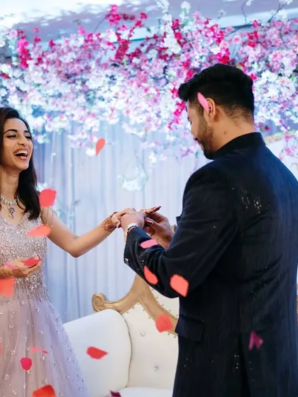 The ring exchange, captured amidst a shower of petals against a stunning cherry blossom-themed backdrop. A perfect blend of action and emotion.