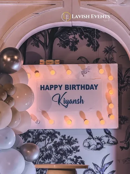 A close-up of the personalized "Happy Birthday Kiyansh" sign with marquee-style lights, part of the carnival theme.