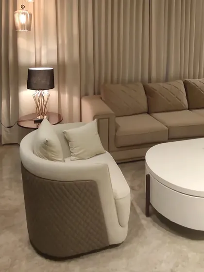 Furniture selection is key to creating a mood. This image shows the elegant and subtle furniture chosen for one of our sites, featuring a curved armchair and a modern coffee table.