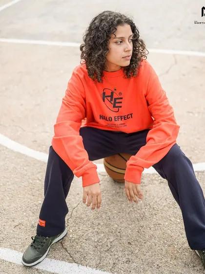 The Halo Effect sweatshirt styled for a casual, athletic look on the basketball court. Its vibrant color and comfortable fit make it a versatile piece.