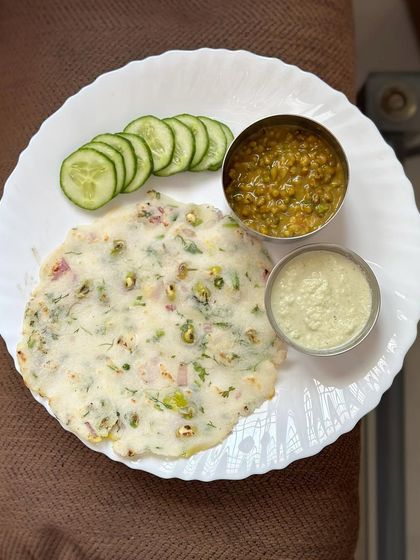 A healthy South Indian breakfast of akki roti, served with green gram dal, coconut chutney, and fresh cucumber.