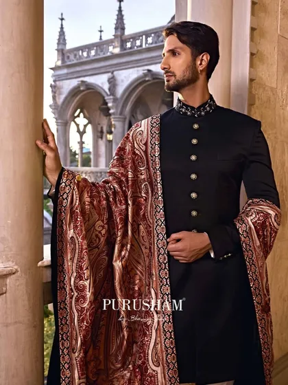 There is timeless power in a classic black bandhgala. I paired this one with a richly detailed woven shawl, a piece of art in itself. This is for the man who carries the whispers of kings and the poetry of centuries past.