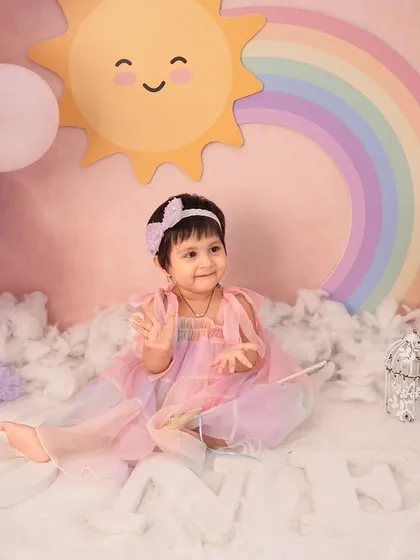 Sitting like a little queen in her sunshine and rainbow kingdom. The letter board and "ONE" blocks add a personalized touch to this first birthday photoshoot.