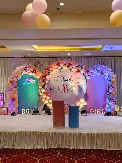 A wide view of the "We Can Bearly Wait" baby shower stage setup in a large hall.