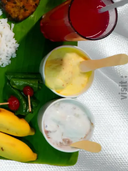 A complete meal with dessert. This banana leaf spread includes non-veg items, rice, juice, and two types of ice cream to finish the feast.
