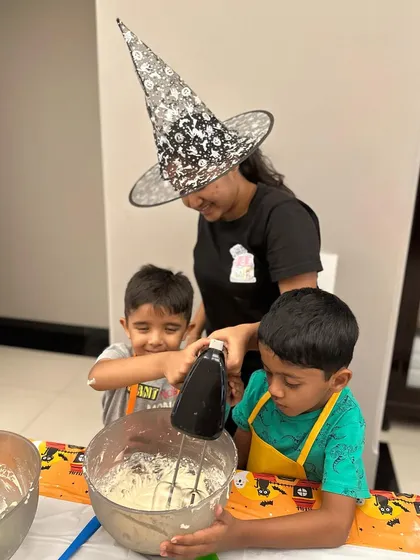 My kids' workshops are 100% hands-on. I guide them, but they do all the fun stuff themselves, from using the mixer to whipping up frosting for their spooky Halloween cupcakes.