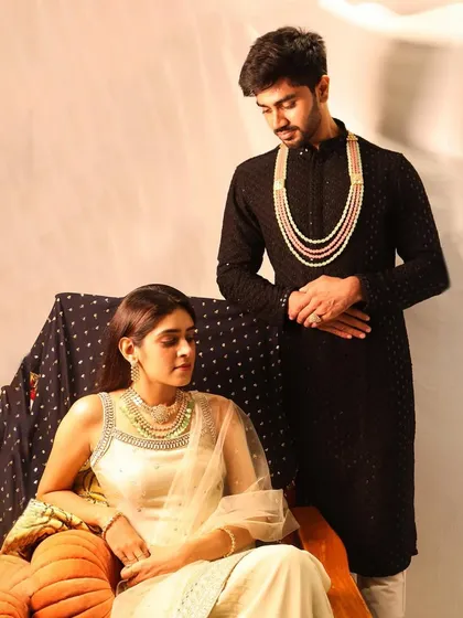 A coordinated couple's look featuring our Polki jewellery. She is wearing a detachable Polki necklace with emeralds, while he wears a matching multi-layered piece from our men's collection.