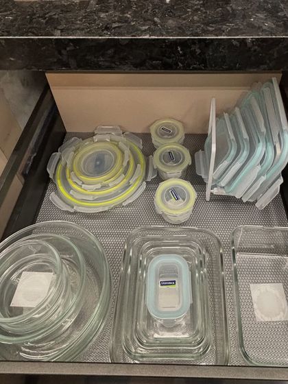 This drawer holds a variety of glass and collapsible silicone containers. We've grouped them by type and stacked the lids neatly to save space.
