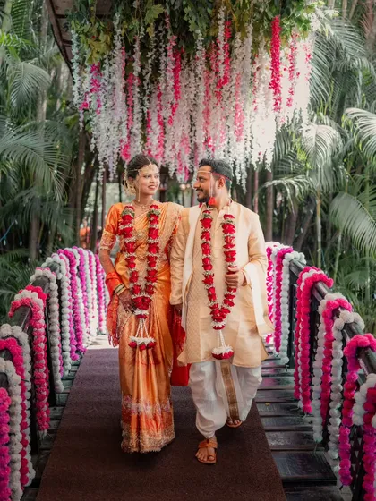 A quiet walk across a bridge adorned with flowers at a beautiful Maharashtrian wedding in Thane. This image captures the grace and connection of the couple, showcasing the timeless elegance of traditional ceremonies.