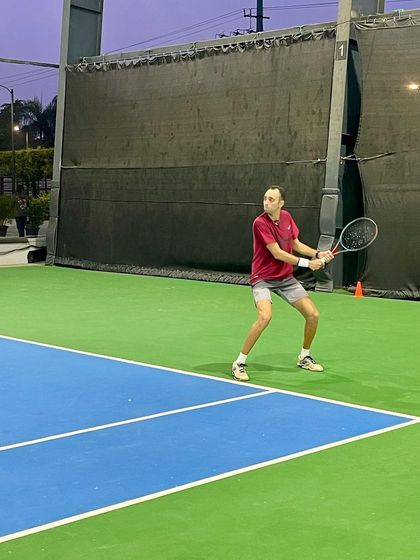 An adult player returns a shot with focus and determination during a UTR tournament. Our training programs cater to competitive players of all ages.