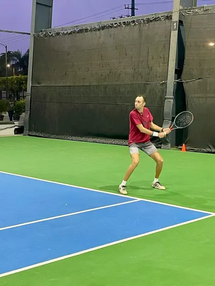 An adult player returns a shot with focus and determination during a UTR tournament. Our training programs cater to competitive players of all ages.