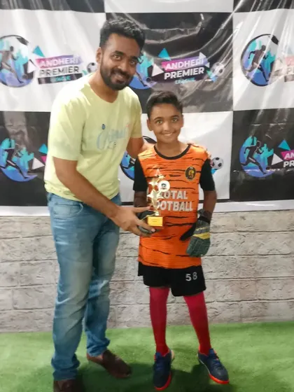 A young goalkeeper receives an award for his excellent saves.