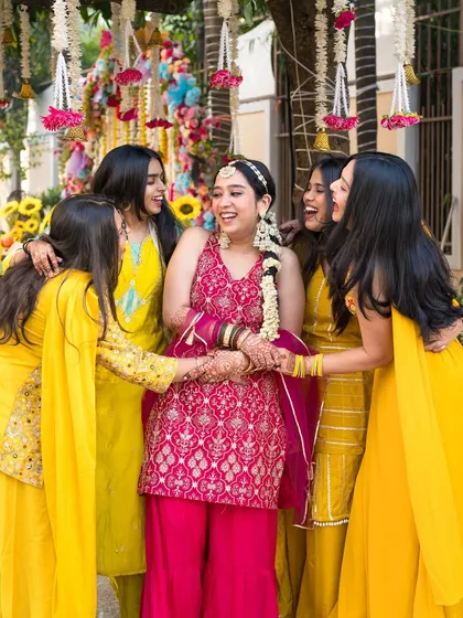 The bride surrounded by her best friends, sharing a laugh during the Haldi ceremony. These are the unscripted moments with your bride tribe that you will cherish forever.