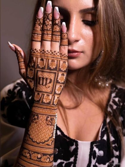 A close-up of a bridal back-hand design, featuring personalized initials set within a beautifully detailed grid pattern.