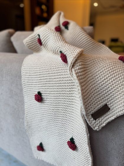 A close-up view of the cream rose muffler, showing our branded leather tag. It's a small detail that signifies the authentic, handmade quality of our work.