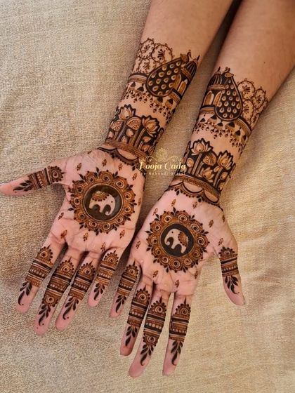 A lovely Karwa Chauth design featuring central mandalas with small elephants. The back of the hands are adorned with lotus patterns and peacock-inspired shapes for a balanced and festive look.