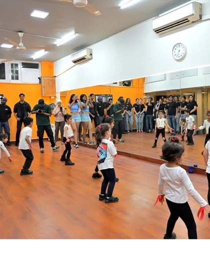 The whole group, kids and parents, watching a demonstration during a kids' class. It's a community affair.