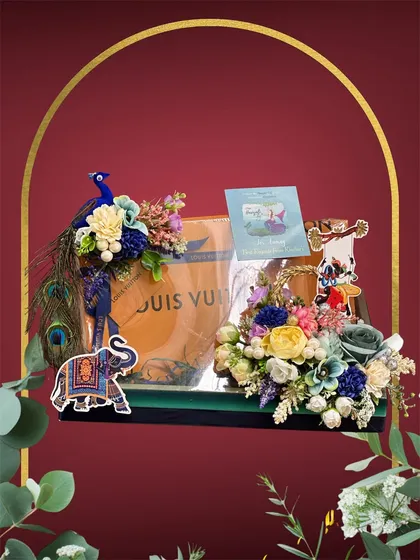 We can incorporate any gift into our designs. Here, we created a stunning floral and peacock arrangement around a Louis Vuitton bag, making the gift presentation as luxurious as the gift itself.