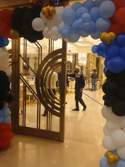 The balloon arch at the entrance, setting the tone with the theme's red, blue, black, and white colors.