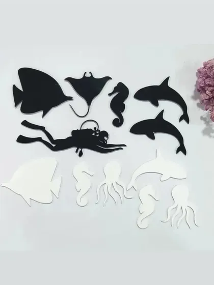 Our ocean art supplies include these black and white acrylic cutouts of sea creatures. The set includes dolphins, a stingray, an octopus, and a scuba diver for creating realistic underwater scenes.