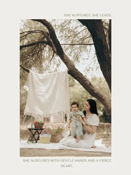 A mother's gentle love captured in a beautiful outdoor setting. This portrait of a mother and her baby enjoying a picnic is a testament to her nurturing heart.