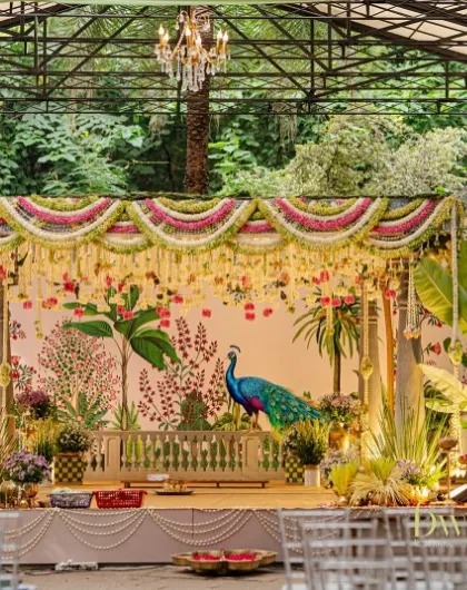 We brought a touch of royal heritage to this South Indian wedding with a custom-designed mandap. The backdrop features hand-painted Pichwai art with a majestic peacock, framed by pillars and lush floral arrangements, creating a sacred and elegant space for the ceremony.