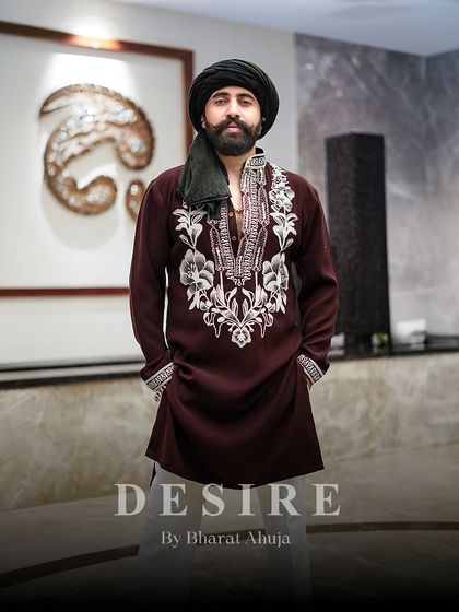 A full view of a powerful ensemble. The rich maroon kurta with its striking white floral embroidery creates a look of undeniable presence and classic charm.