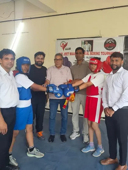 Officials and coaches overseeing the start of a competitive youth boxing match, ensuring all rules and safety measures are followed.