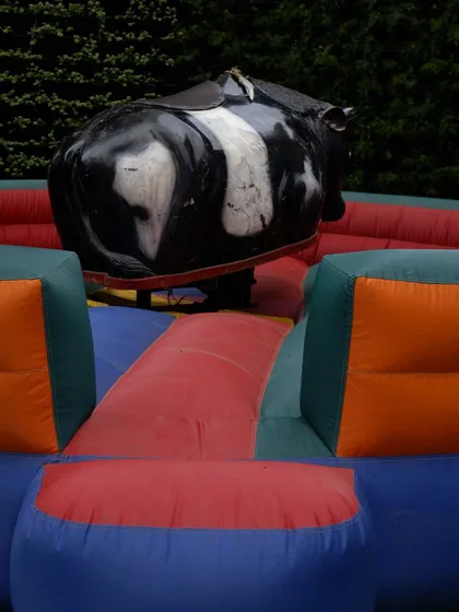 A close-up of the mechanical bull, showing the saddle and the protective inflatable landing area. An operator is always included to ensure safe fun for all riders.