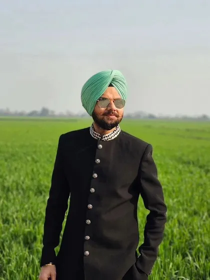 Comedian Jaspreet Singh looking sharp in our black Indo-western sherwani against a classic Punjabi backdrop. This outfit features a detailed collar and statement buttons.