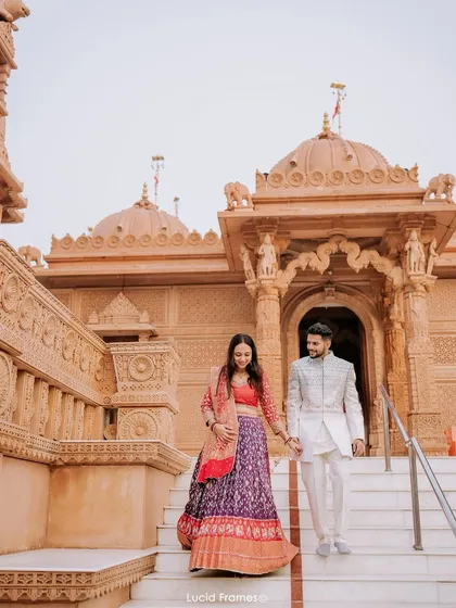 Hand in hand, descending the steps of a timeless temple. This shot captures the beginning of their journey together with cultural richness and elegance.