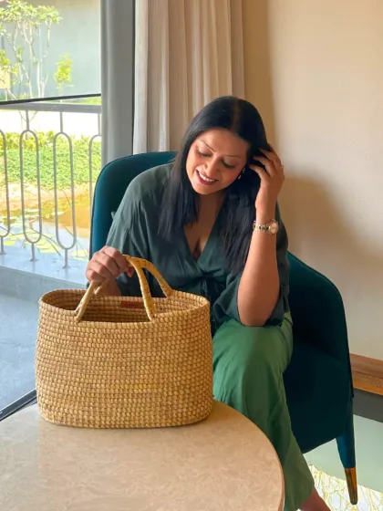 Styling the sustainable Sirohi Moonj grass bag. Here, it's paired with a simple green co-ord set, allowing the bag's natural texture to stand out.