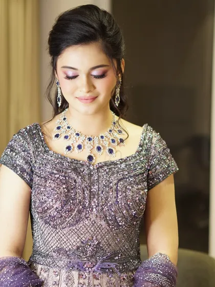 This look was a vision of timeless glamour. I used a soft lilac shimmer on the eyes to complement her regal sapphire and diamond necklace. The result was an ethereal glow that was even more breathtaking in person.