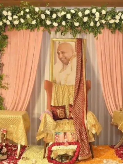 Here is another style for a Guru Ji event, featuring a floral arch of white carnations over soft peach drapes. The altar uses golden fabrics and a deep red sash to create a warm and respectful setting, with rose petals scattered on the floor.