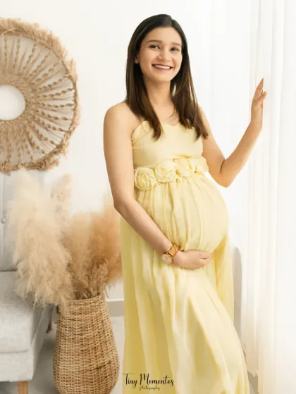 This portrait captures the pure joy and excitement of pregnancy, with a radiant smile that lights up the entire frame.