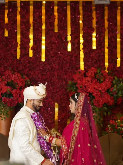 The Varmala ceremony is full of emotion. I captured this moment of the couple looking at each other, with the grand red and gold decor creating a royal backdrop.