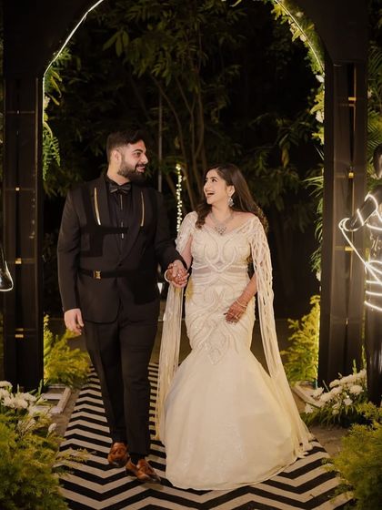 Our beautiful bride redefines ivory elegance in a fish-cut silhouette, draped in a sea of sequins and finished with dramatic floor-sweeping sleeves.