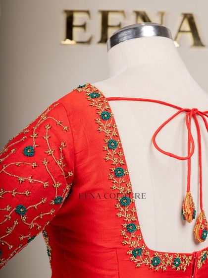 A simple yet striking design. This bright red raw silk blouse features a delicate creeper embroidery pattern in gold and teal thread, with a classic square back and matching handmade tassels.
