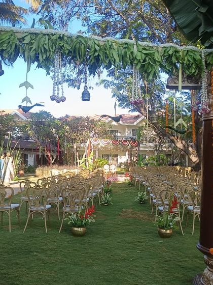 This entrance to an outdoor wedding ceremony was decorated with traditional pillars wrapped in marigold garlands. The archway made of mango leaves and hanging bells adds to the authentic, rustic charm.