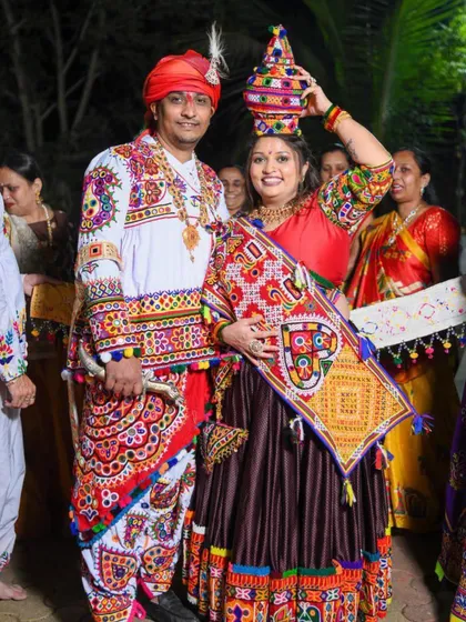 The happy couple in their vibrant traditional attire. Her makeup is bright and festive to match the energy of the event.
