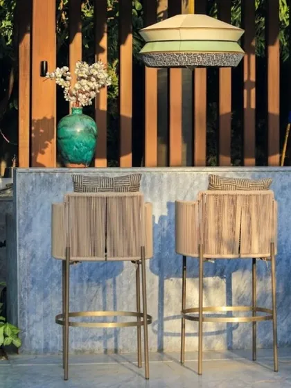 A detailed shot of the custom bar stools, which feature woven details and brass frames, echoing the luxurious material palette of the home's interior.
