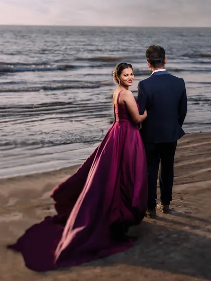 A cinematic moment at dusk. The way her gown catches the sea breeze creates a truly dramatic and romantic pre-wedding portrait. This is about making you feel like the heroes of your own love story.