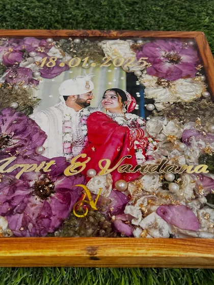The final varmala preservation frame, a beautiful testament to Arpit and Vandana's special day. Their wedding photo is surrounded by their own preserved flowers, creating a truly personal piece of art.