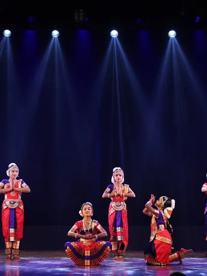 A large group of my students on stage, their synchronized poses and vibrant costumes creating a stunning visual spectacle under the professional stage lighting.