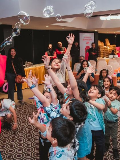 The bubble artist creating a stream of bubbles that mesmerizes the children. This form of entertainment is perfect for kids of all ages.