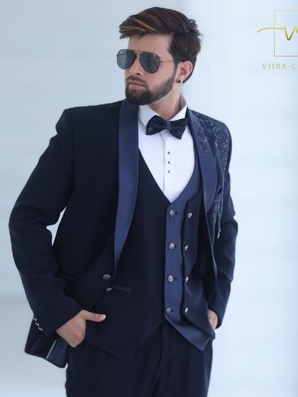 A close-up on the details of the navy tuxedo, from the lapel to the embroidered shoulder.