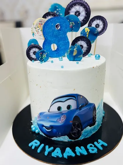 Another car-themed cake, this one for an 8th birthday, with a blue car and wheel toppers.
